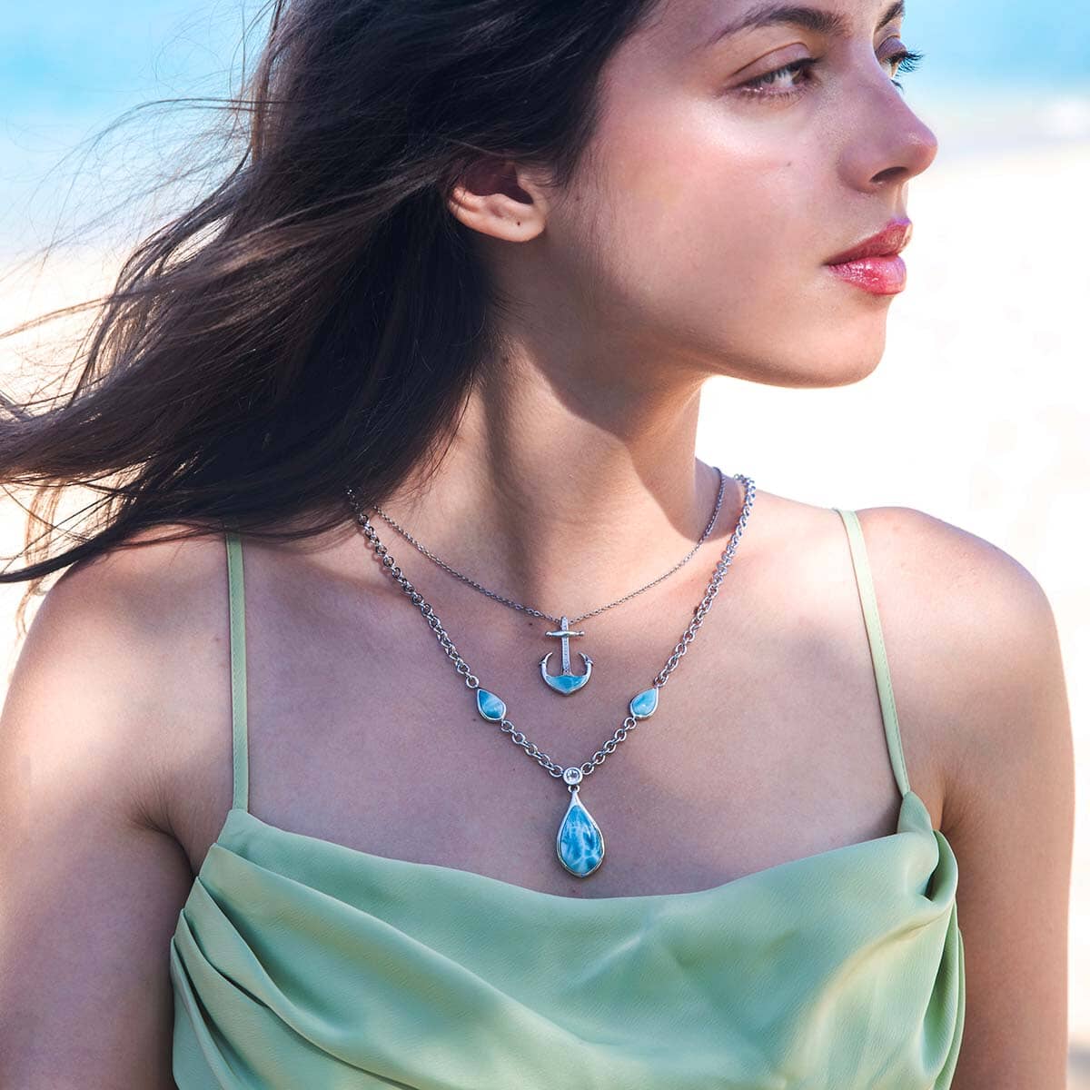 The art of layering necklaces featuring larimar teardrop necklace and larimar anchor pendant