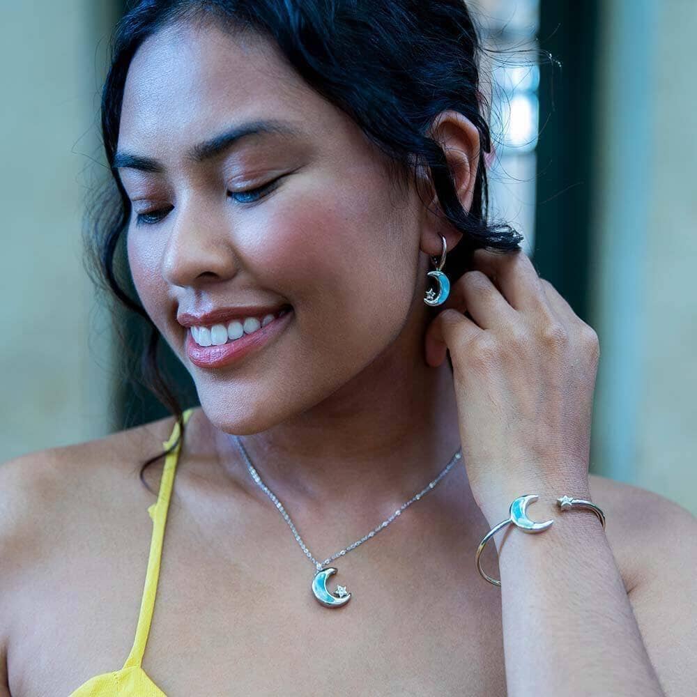 Model wearing the larimar star and moon set including a pendant, earrings and a sleek or flexi bangle