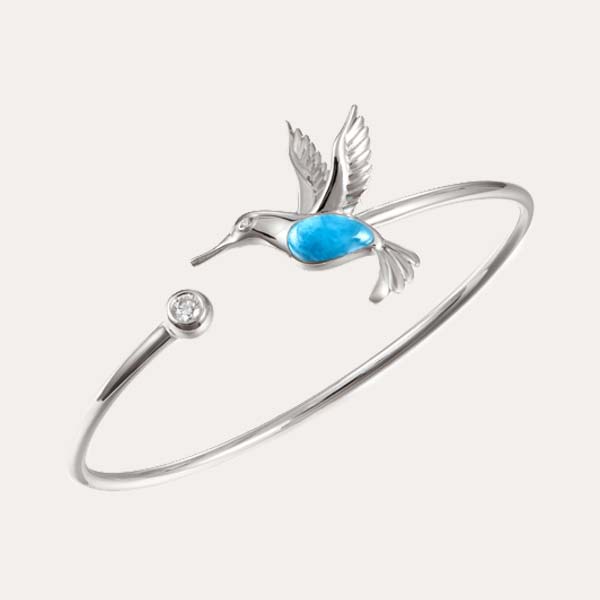 garden bracelets collection featuring a silver flexi bangle with an ocean blue larimar humming bird and a white topaz on the opposite end