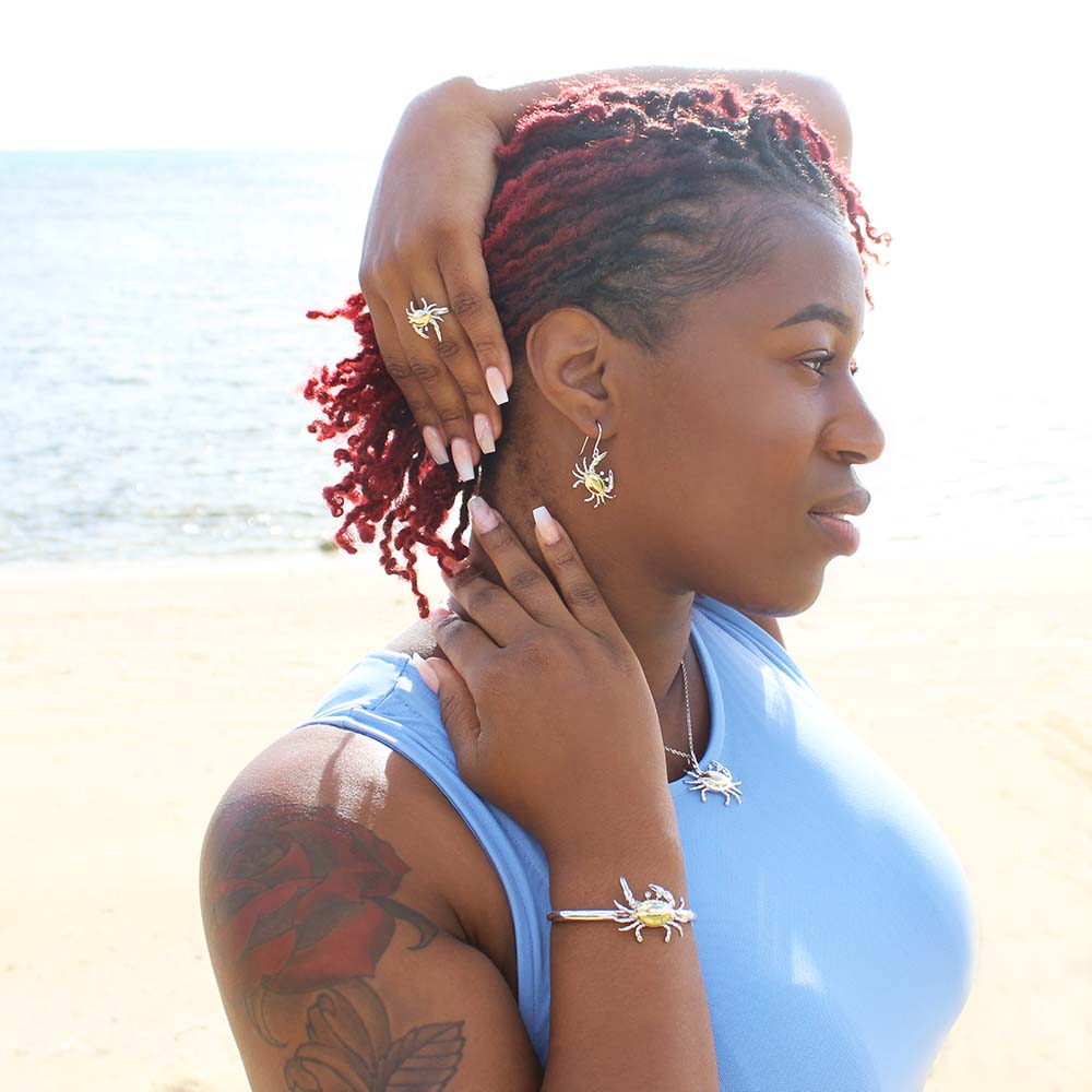 two tone blue crab jewelry set worn by a model on the beach