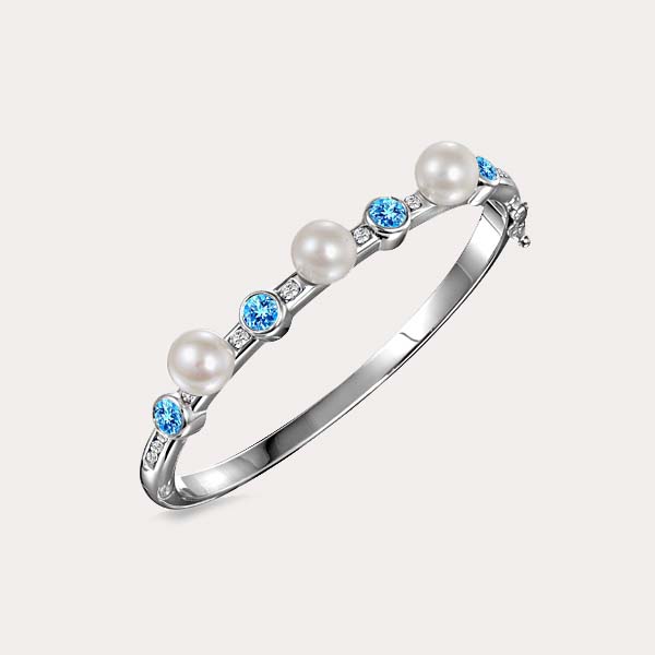 pearl bracelet collection featuring a solid hinge bangle with blue topaz gemstone alternating with white pearls