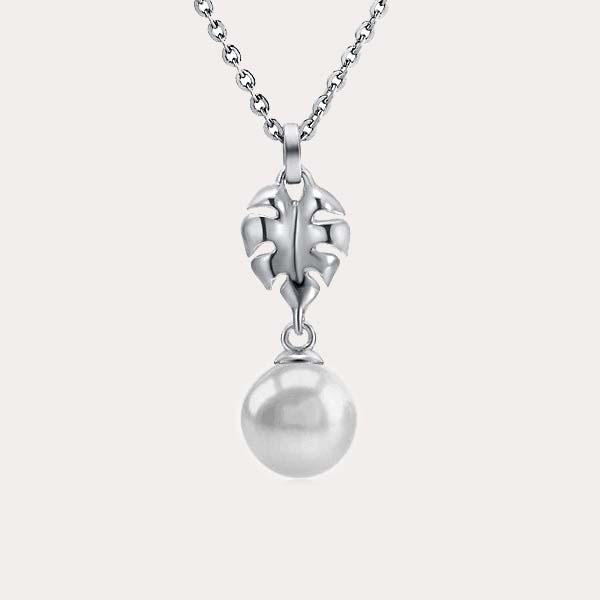 pearl pendant collection featuring a monstera leaf design with a white pearl dangling at the end of the pendant