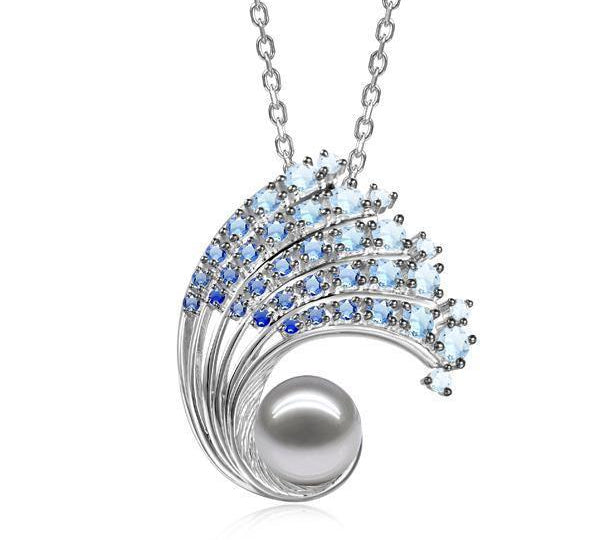 In this photo there is a large white gold ombre wave pendant with gradient blue aquamarine gemstones and one white Akoya pearl.