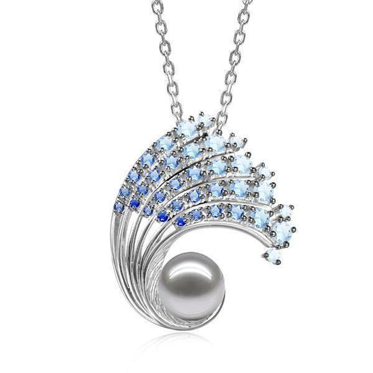 In this photo there is a large white gold ombre wave pendant with gradient blue aquamarine gemstones and one white Akoya pearl.