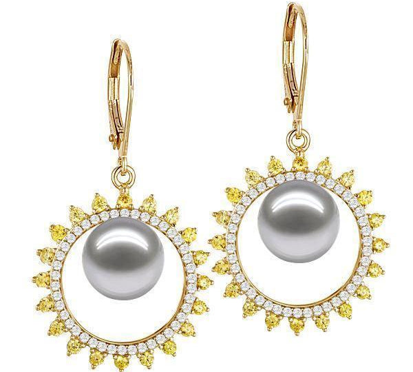 In this photo there is a pair of yellow gold sun earrings, with yellow and white diamonds and white/light gray Akoya pearls.