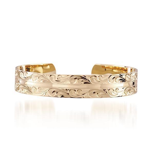 The photo shows a 14K yellow gold bangle featuring a wave engraving.
