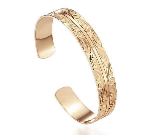 This picture shows a 14K yellow gold Ali'i bangle with a Nalu engraving.