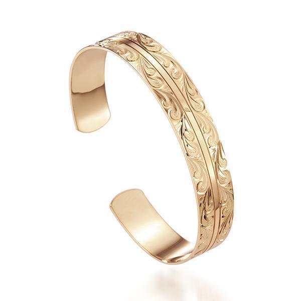 This picture shows a 14K yellow gold Ali'i bangle with a Nalu engraving.