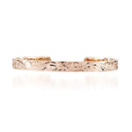 The picture shows a 14K gold bangle with a flower engraving.