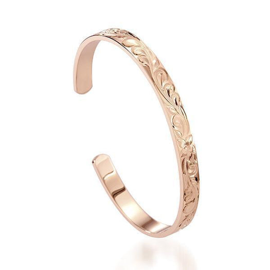 The picture shows a 14K gold bangle with a flower engraving.