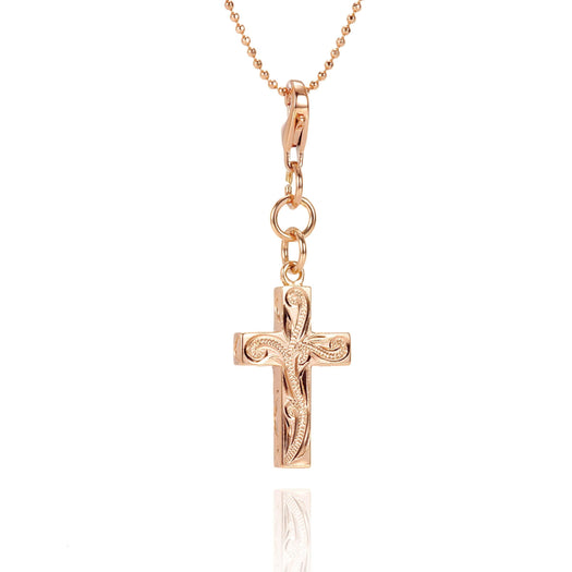 The picture shows a 14K yellow gold cross charm with hand-engraved detailing.