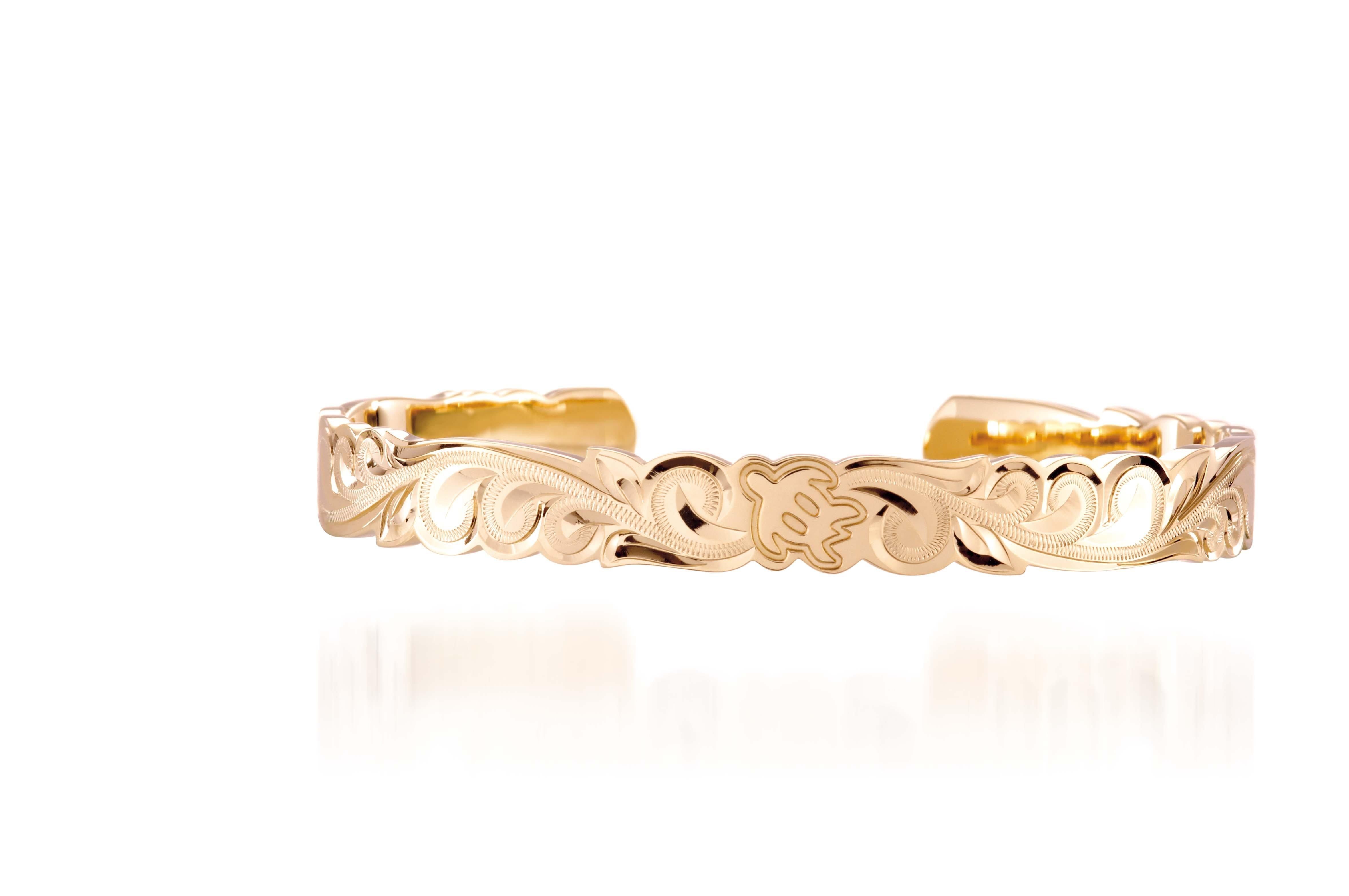The picture shows a 14K yellow gold hand-engraved bangle sea turtle design with cut-out edges.