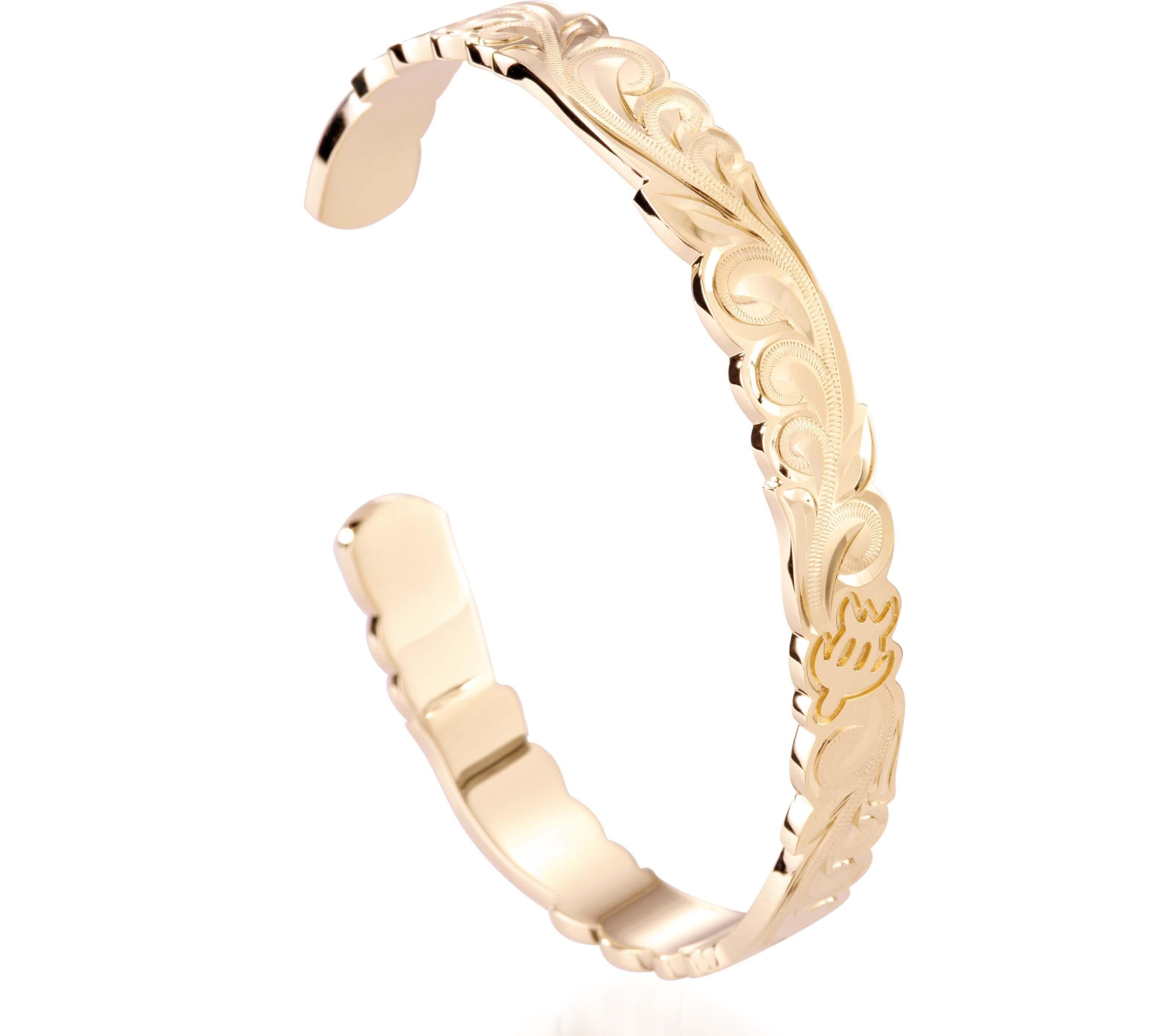 The picture shows a 14K yellow gold hand-engraved bangle sea turtle design with cut-out edges.