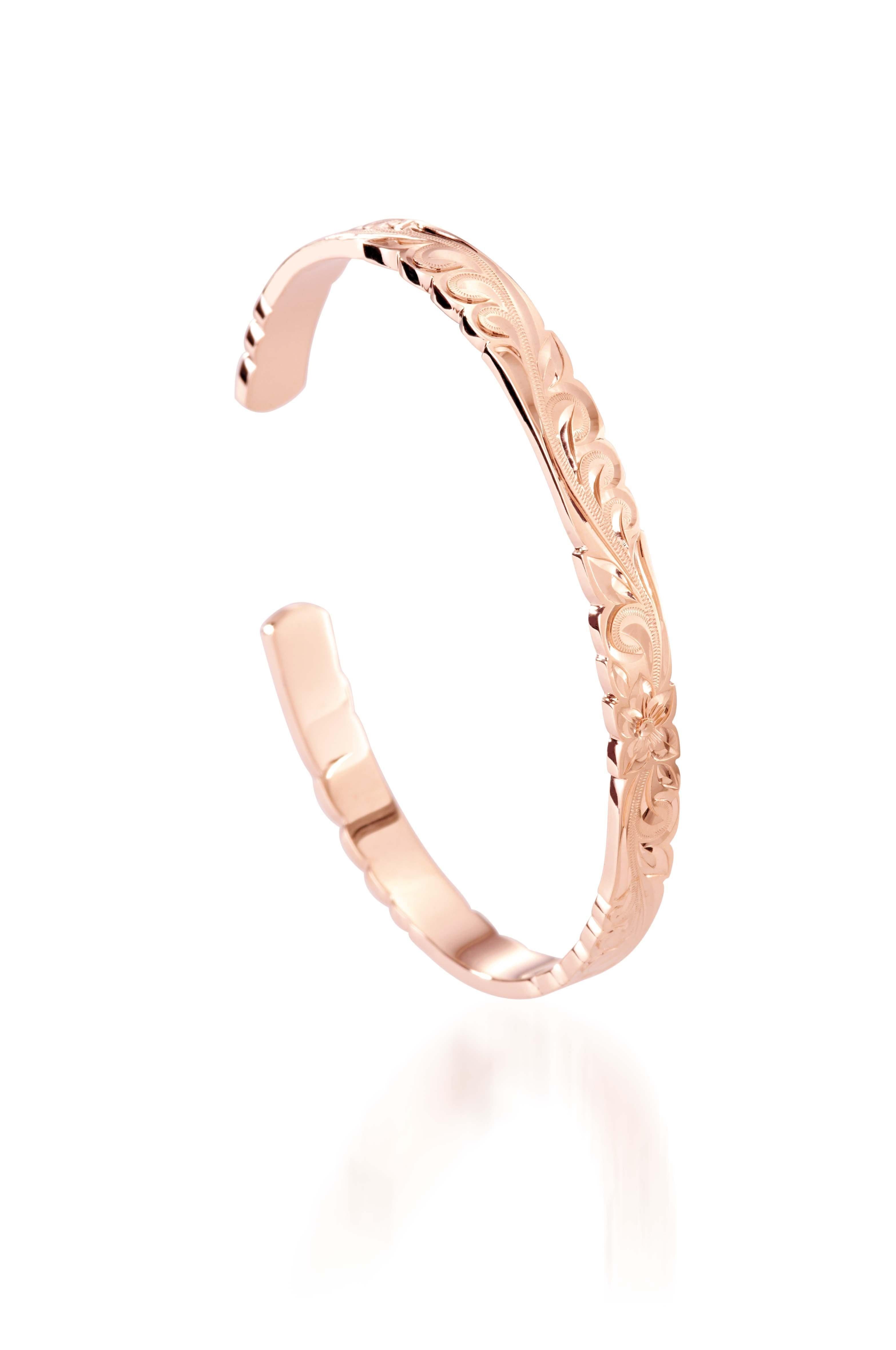 The picture shows a 14K rose gold cut-out bangle with plumeria engraving.