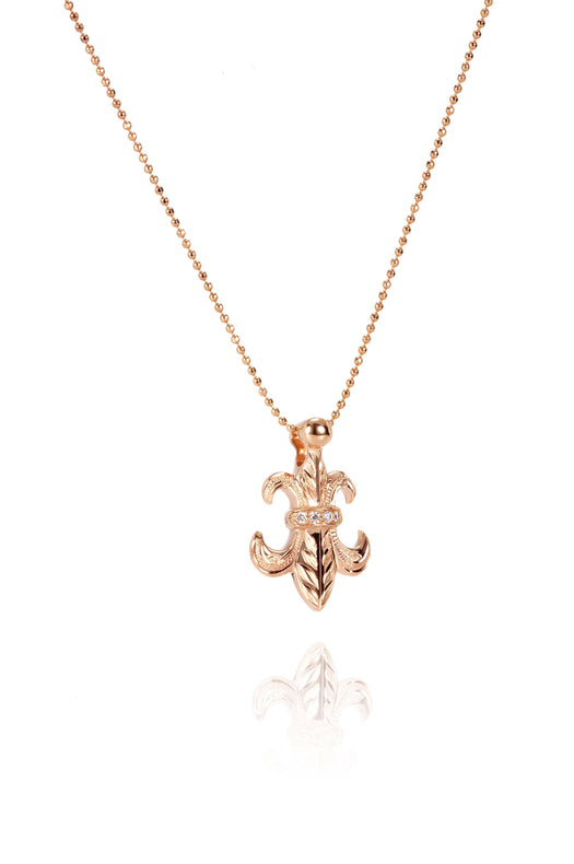 The picture shows a 14K yellow gold fleur-de-lis pendant with hand engravings.