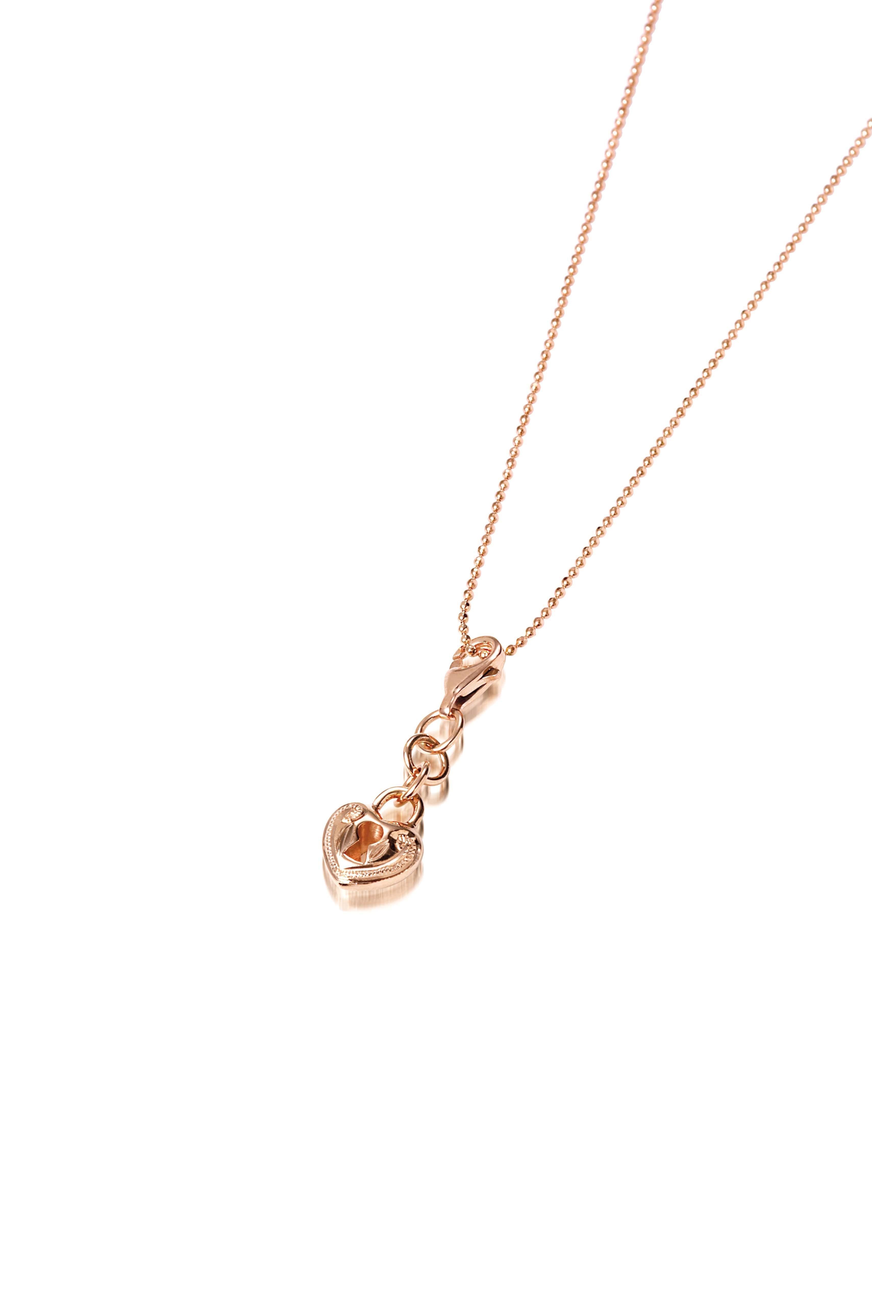 The picture shows a 14K rose gold heart Lock charm with hand-engraved detailing.
