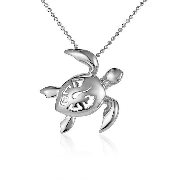 In this photo there is a white gold sea turtle necklace with a hibiscus flower cut-out.