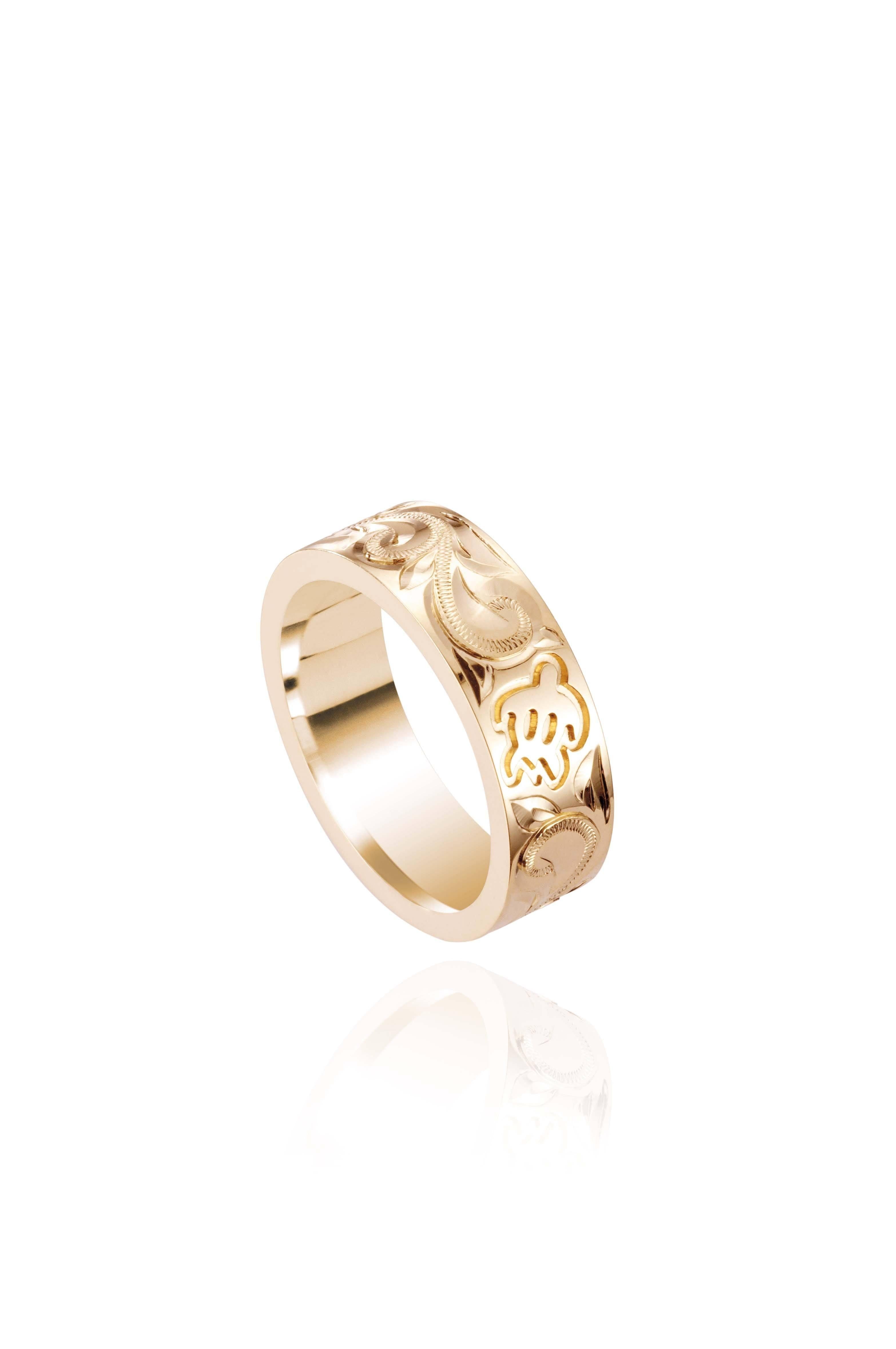 The photo shows a 6 mm 14K yellow gold ring with hand engravings including sea turtles.