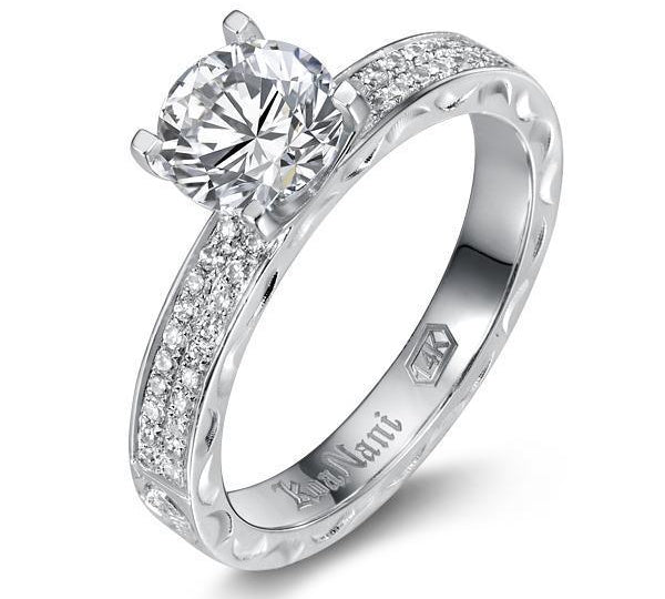 The picture shows a 14K white gold diamond band engagement ring with traditionally inspired hand-engravings.