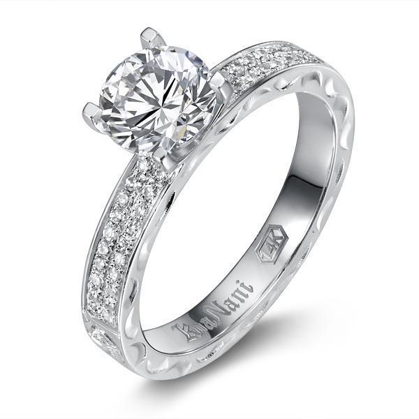 The picture shows a 14K white gold diamond band engagement ring with traditionally inspired hand-engravings.
