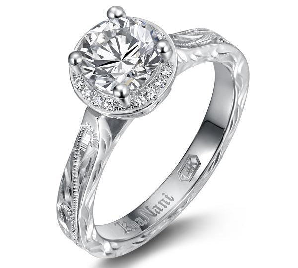 The picture shows a 14K white gold wave engagement ring with diamonds and traditionally inspired hand-engravings.
