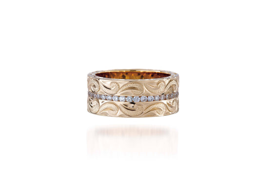 The picture shows a 14K yellow gold wave diamond channel 8 mm ring with hand-engravings.