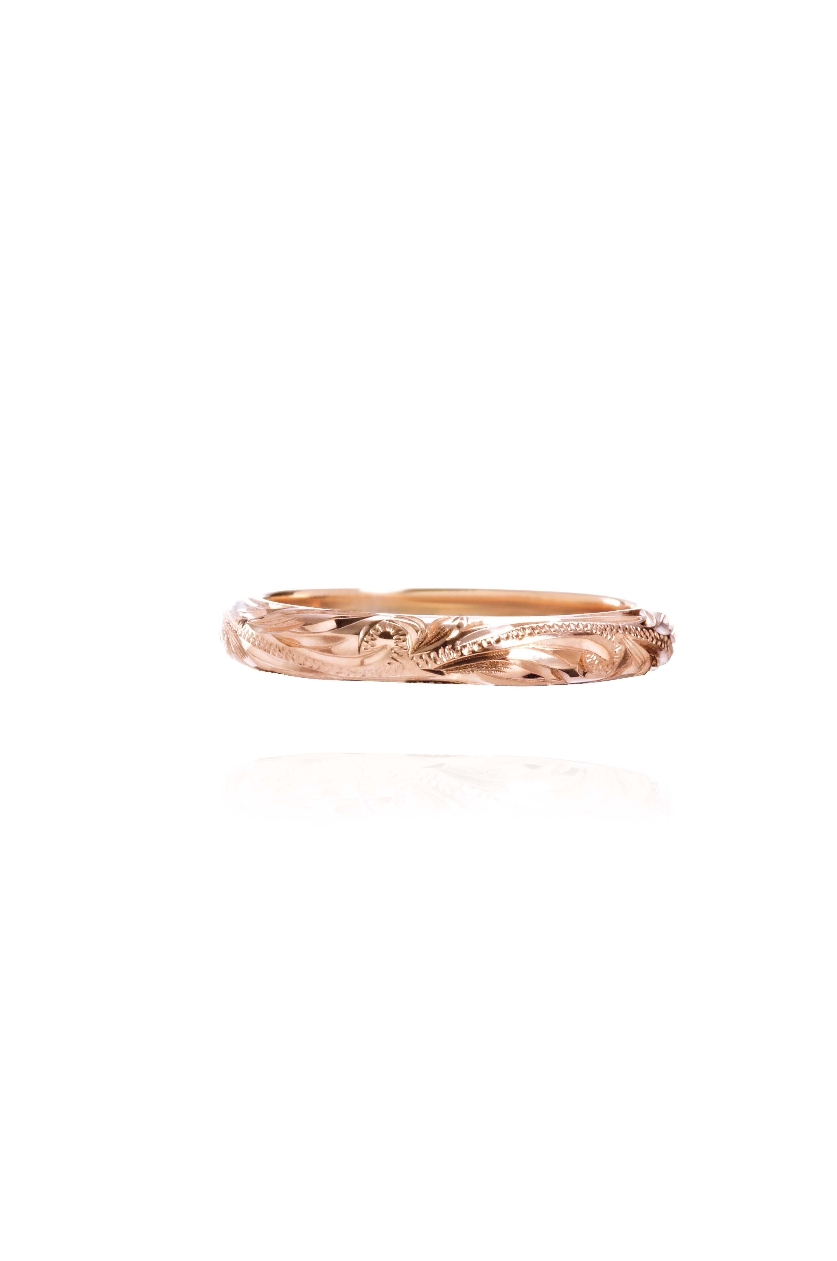The picture shows a 14K rose gold infinity ring with hand-engraved detailing.