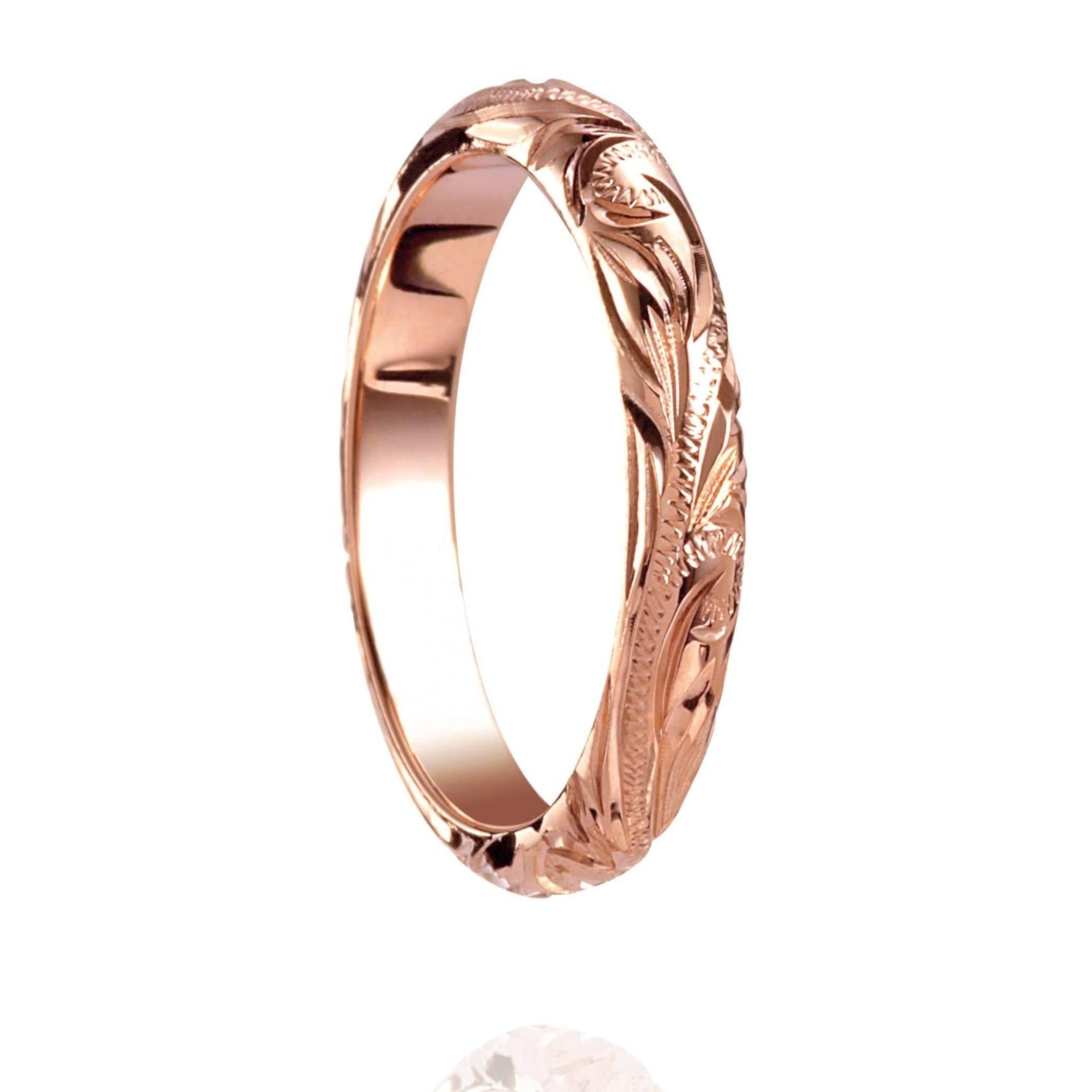 The picture shows a 14K rose gold infinity ring with hand-engraved detailing.