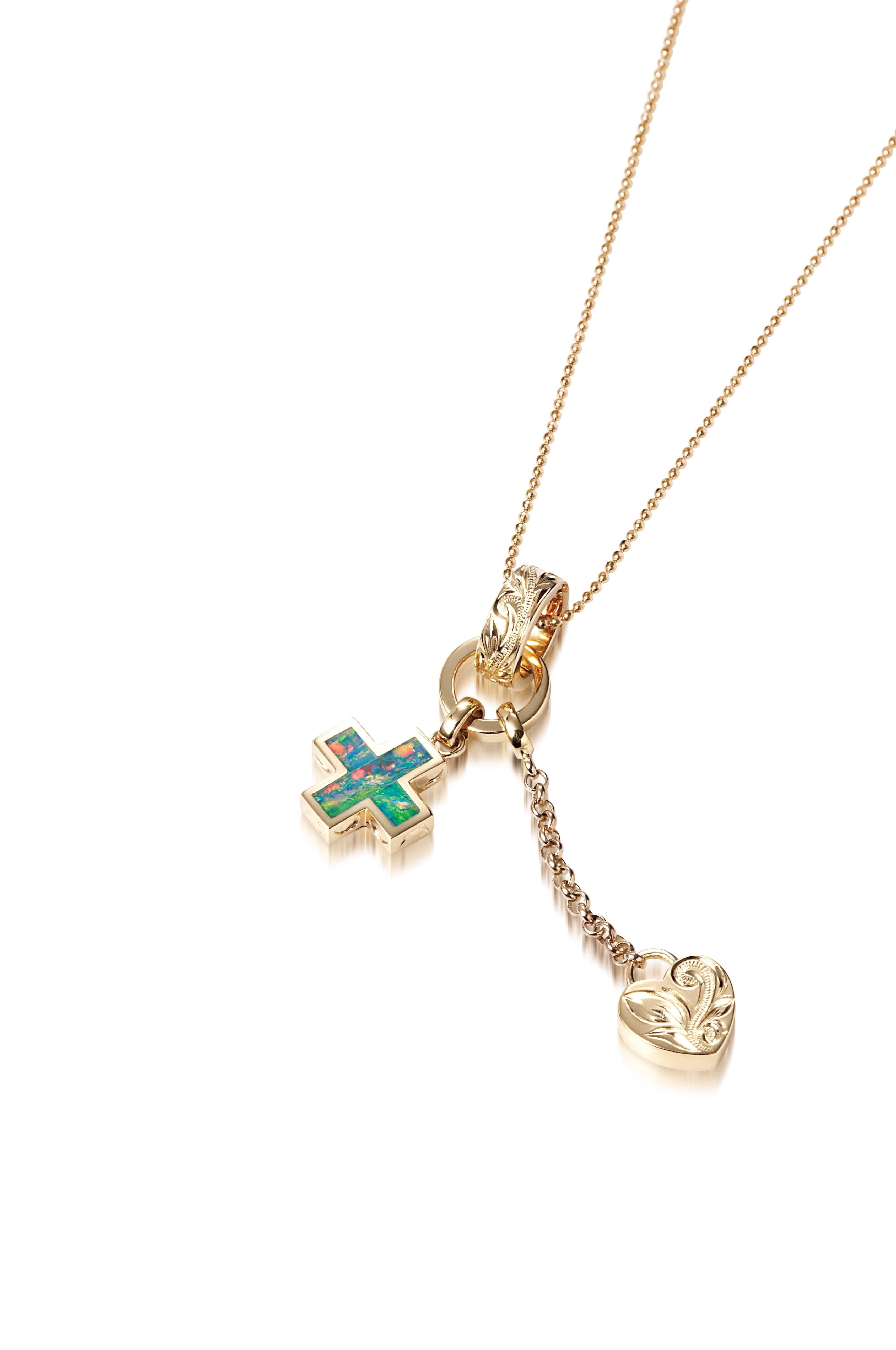 The picture shows a 14K yellow gold opal cross and heart charm pendant with hand engravings.