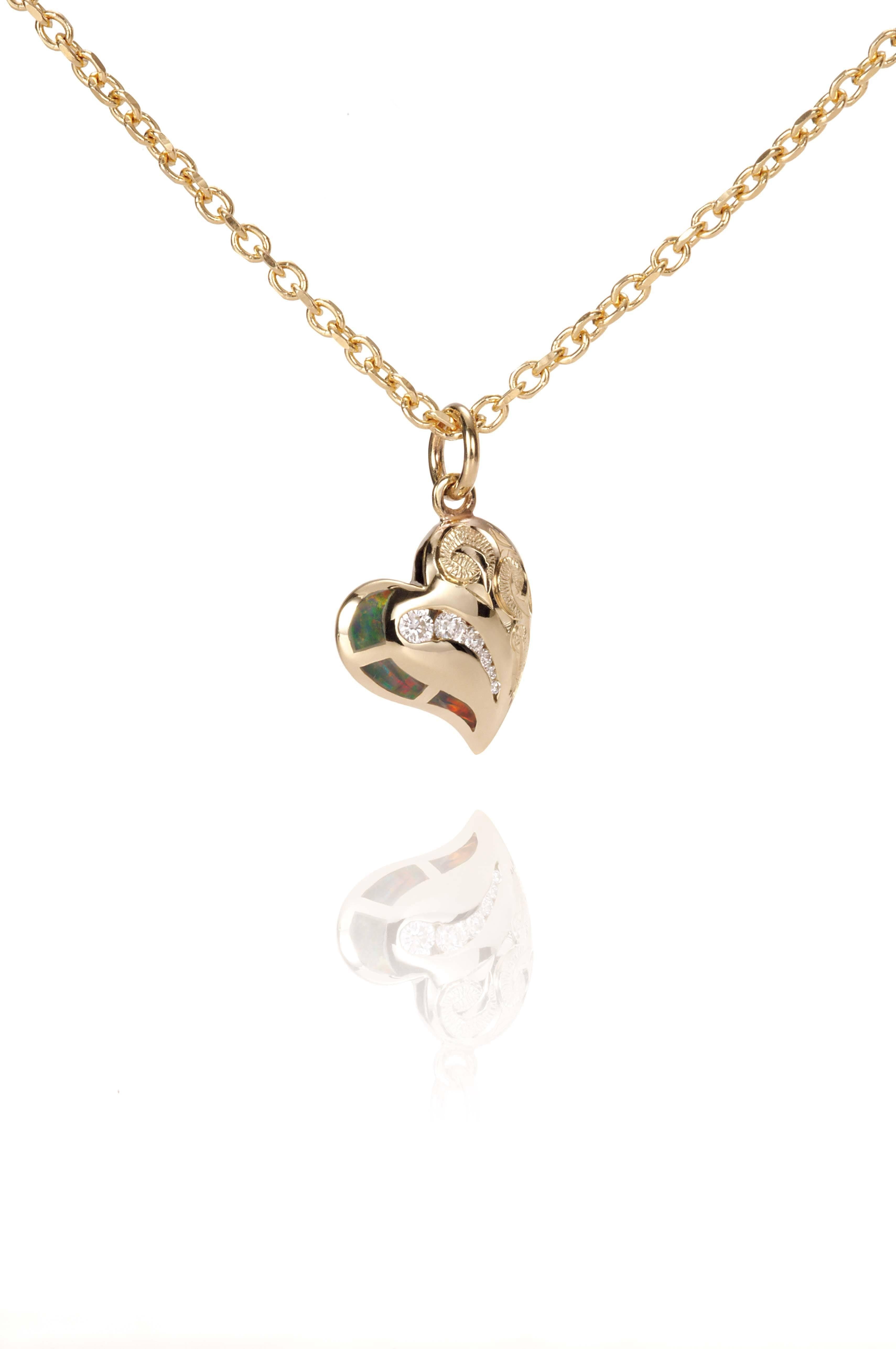 The picture shows a 14K yellow gold opal heart pendant with hand engravings.