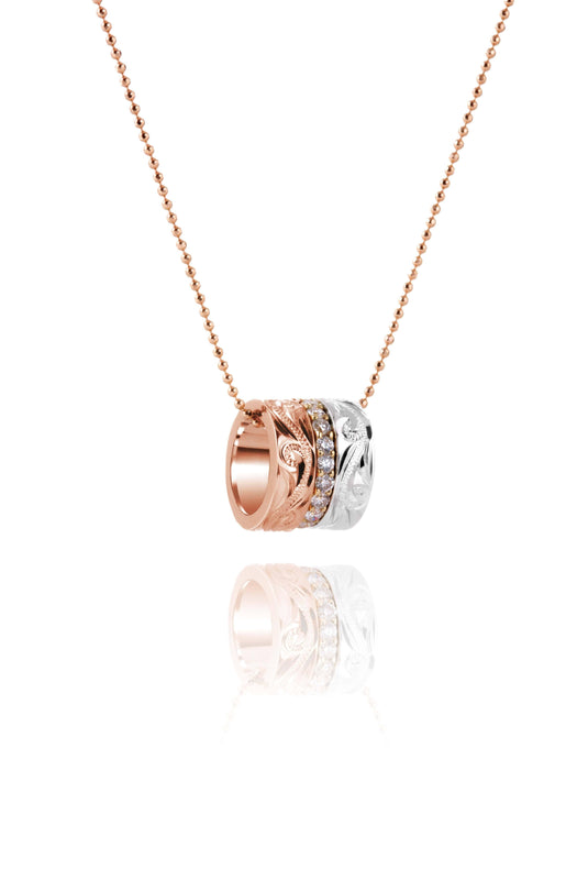 The picture shows a 14K rose, yellow, and white gold barrel pendant with diamonds.