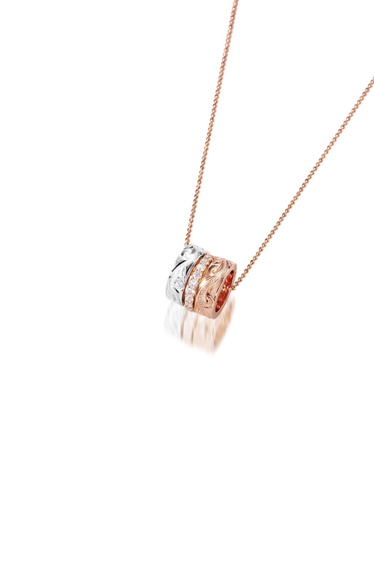 The picture shows a 14K rose, yellow, and white gold barrel pendant with diamonds.