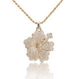 In this photo there is a yellow gold hibiscus pendant with diamonds.