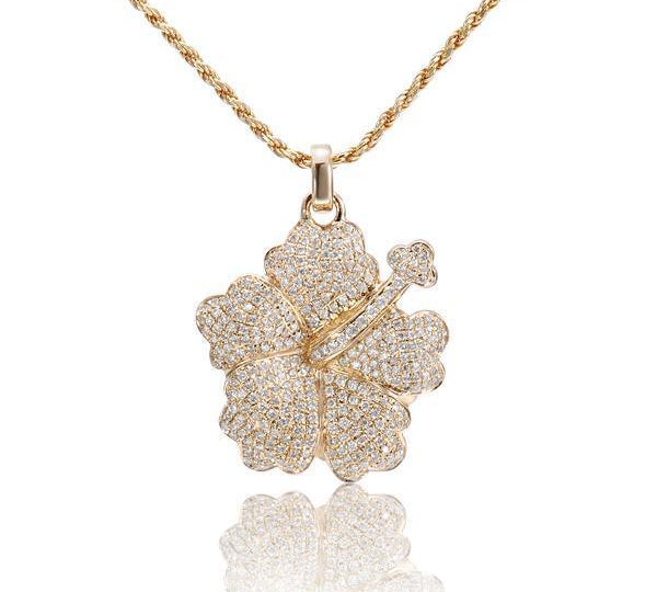 In this photo there is a yellow gold hibiscus pendant with diamonds.