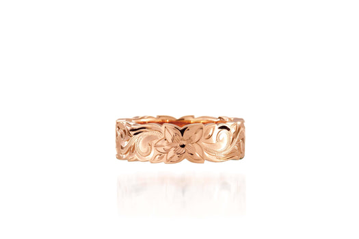 In this picture there is a rose gold cut out ring with hand engravings including flowers and scrolls.