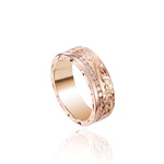 In this photo there is a rose gold ring with diamonds and hand engravings that include a flower and scroll.