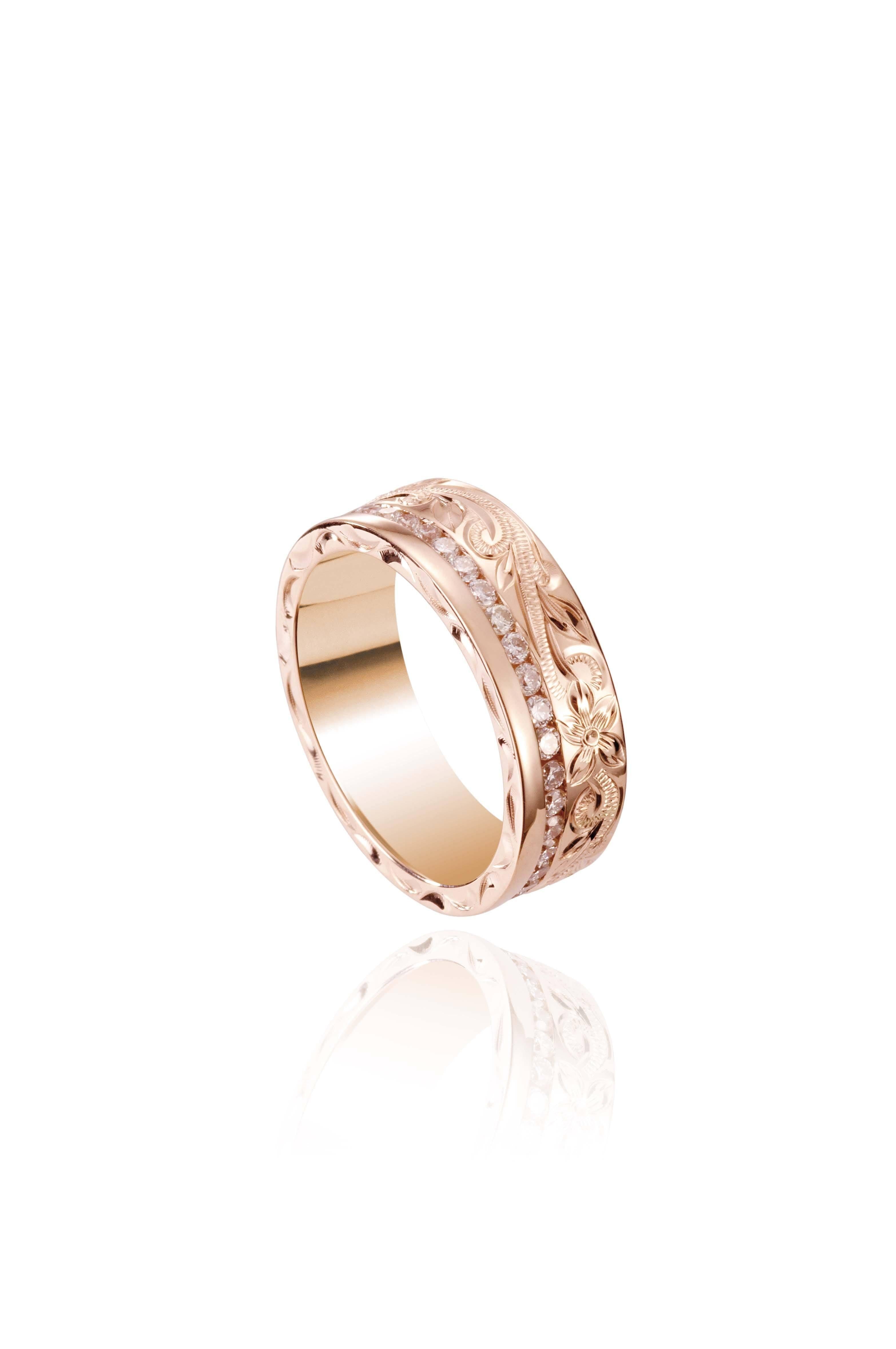 In this photo there is a rose gold ring with diamonds and hand engravings that include a flower and scroll.