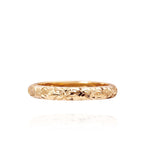 In this photo there is a yellow gold lei ring with flower hand-engravings.