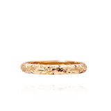 In this photo there is a yellow gold lei ring with flower hand-engravings.