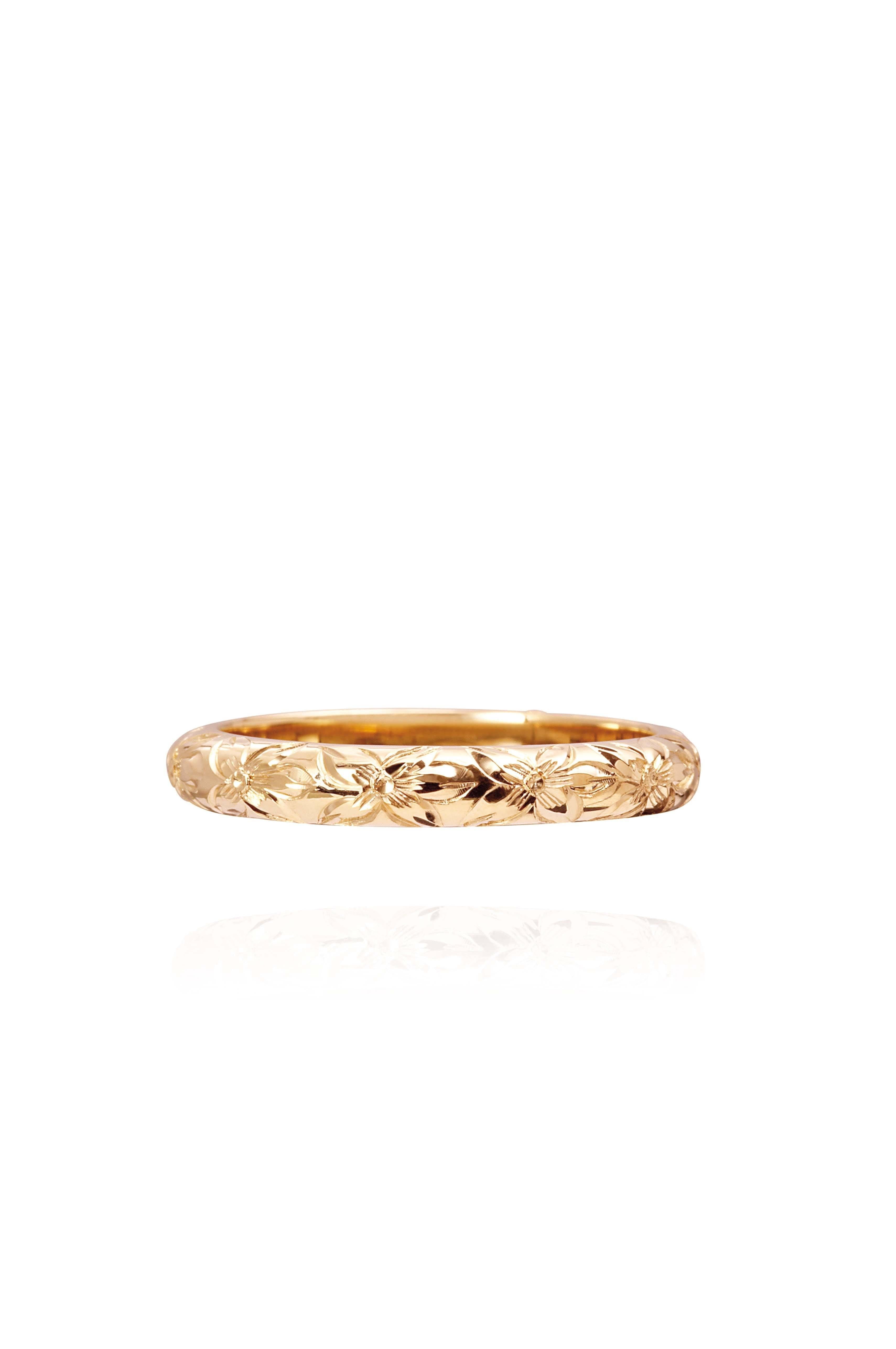 In this photo there is a yellow gold lei ring with flower hand-engravings.