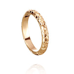 In this photo there is a yellow gold lei ring with flower hand-engravings.