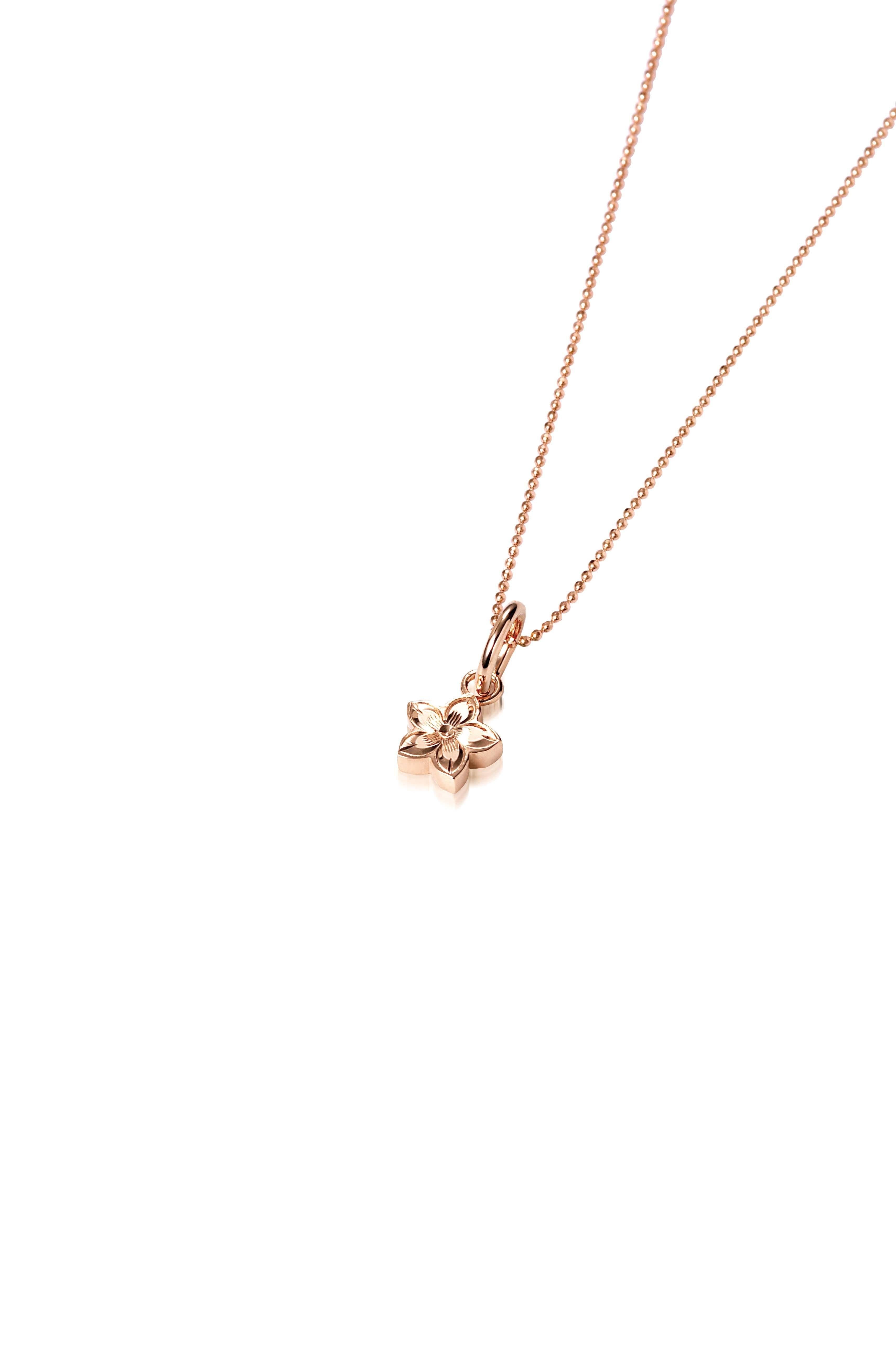 In this photo there is a rose gold plumeria pendant with hand engravings.