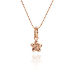 In this photo there is a rose gold plumeria pendant with hand engravings.