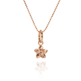In this photo there is a rose gold plumeria pendant with hand engravings.