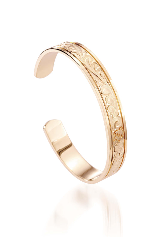 The picture shows a 14K yellow gold royal bangle with sea turtle engravings.
