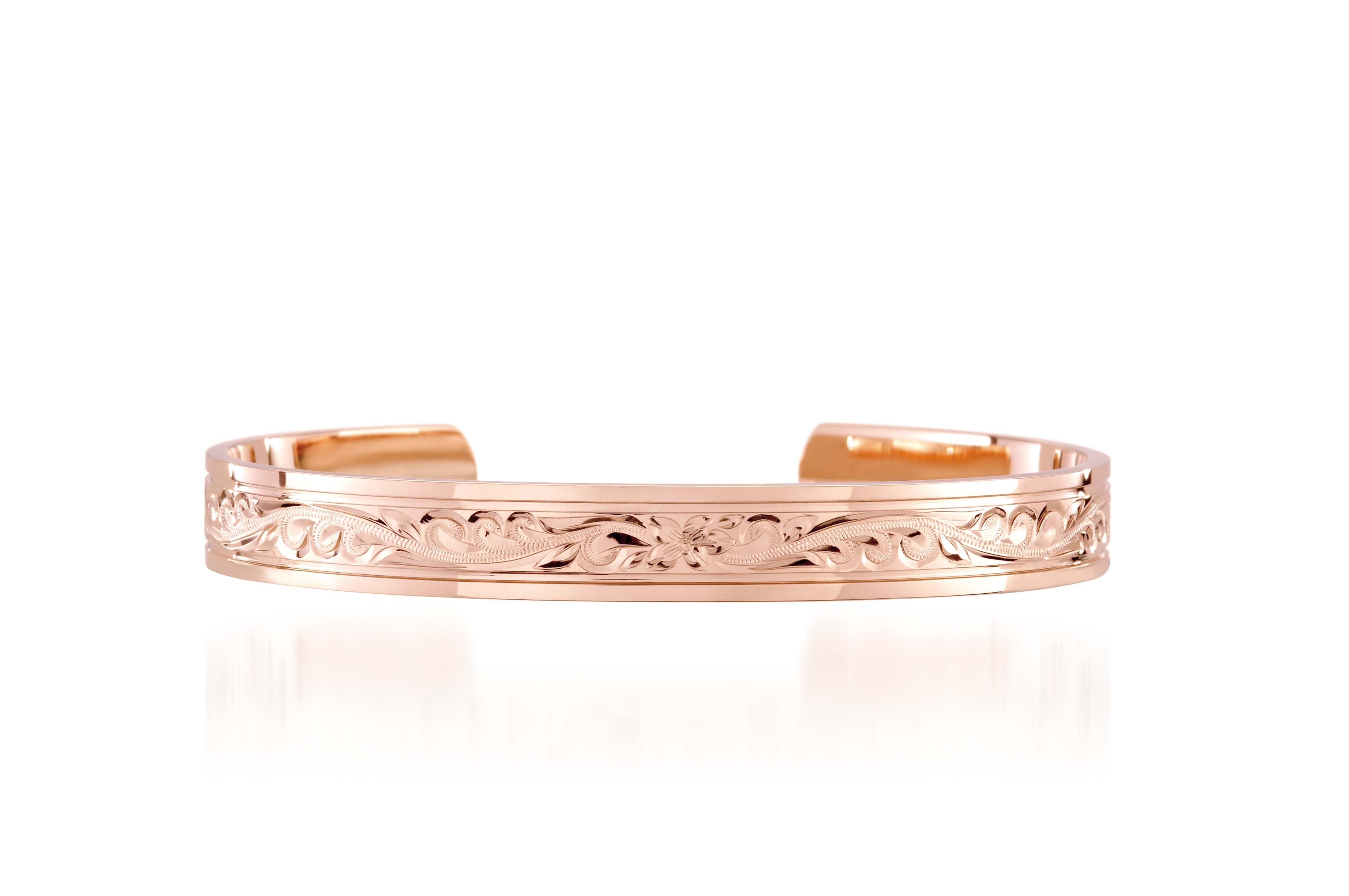 The picture shows a 14K rose gold royal bangle with plumeria engravings.