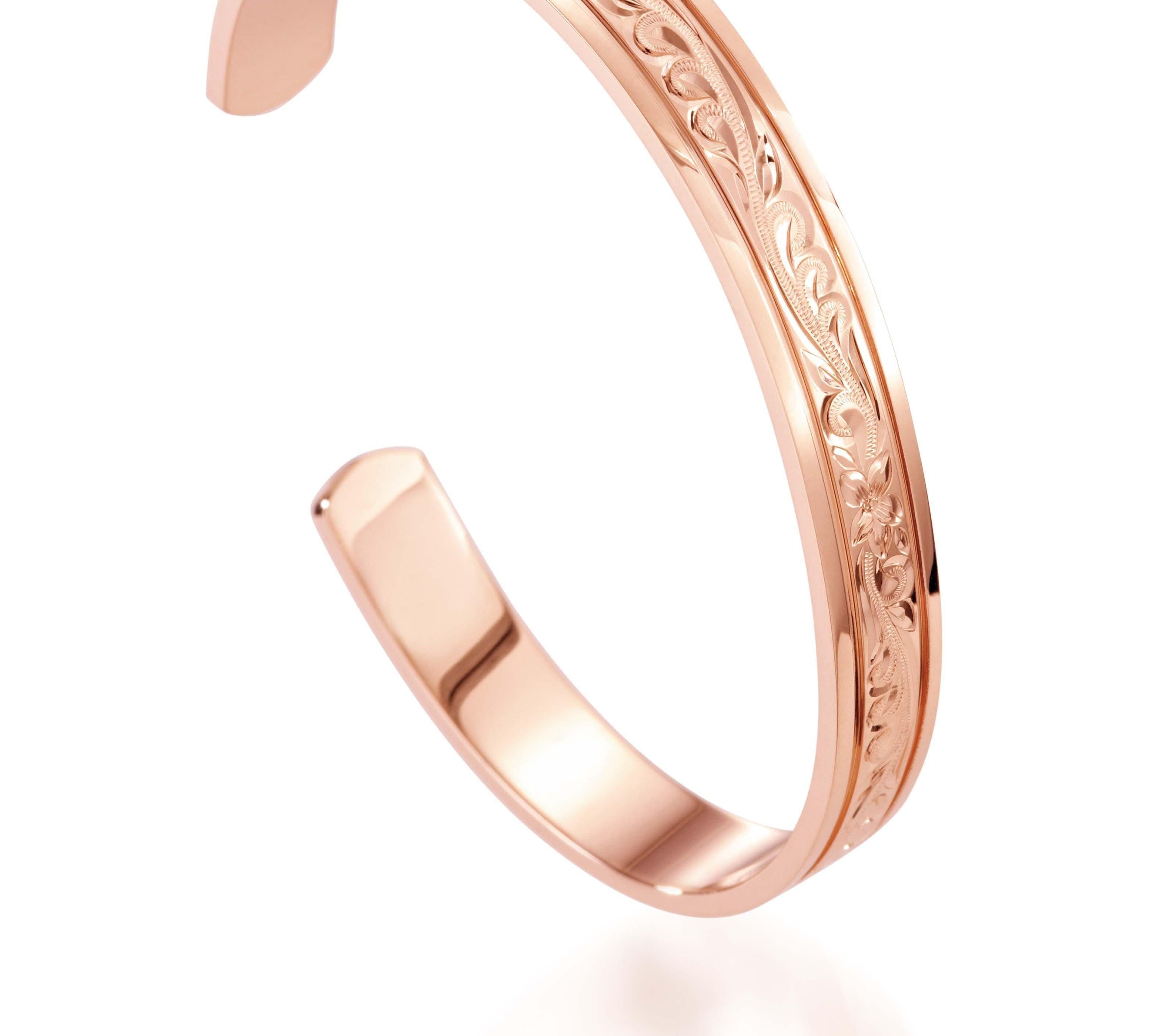 The picture shows a 14K rose gold royal bangle with plumeria engravings.