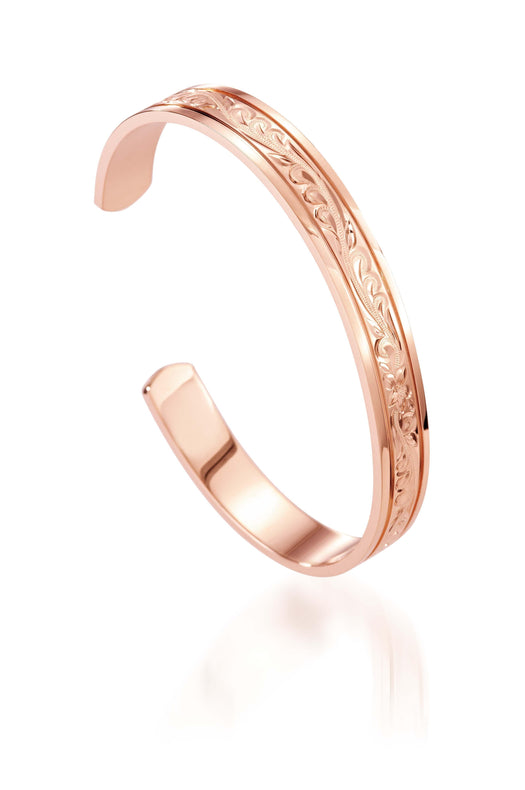 The picture shows a 14K rose gold royal bangle with plumeria engravings.
