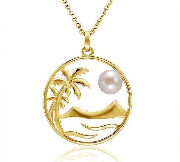 In this photo there is a yellow gold circle pendant with palm trees, diamond head mountain, ocean waves, and one white pearl.