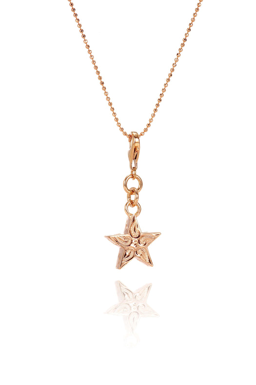 The picture shows a 14K rose gold star charm with paisley hand engravings.